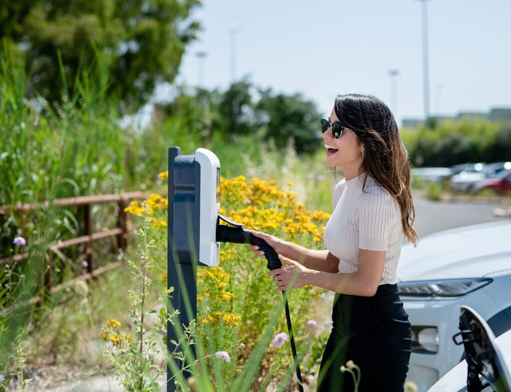 Laughing woman EV charging