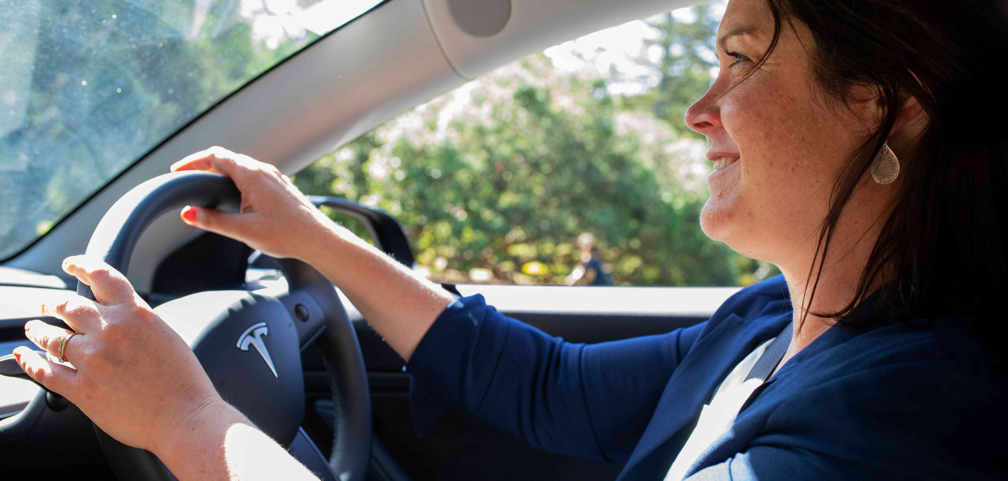 Close up -  a woman driving a Tesla